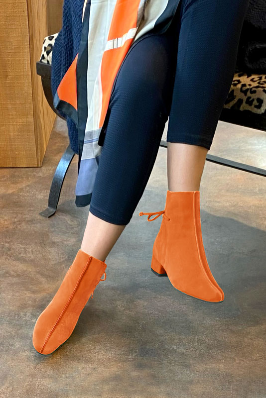 Clementine orange women's ankle boots with laces at the back. Round toe. Low block heels. Worn view - Florence KOOIJMAN